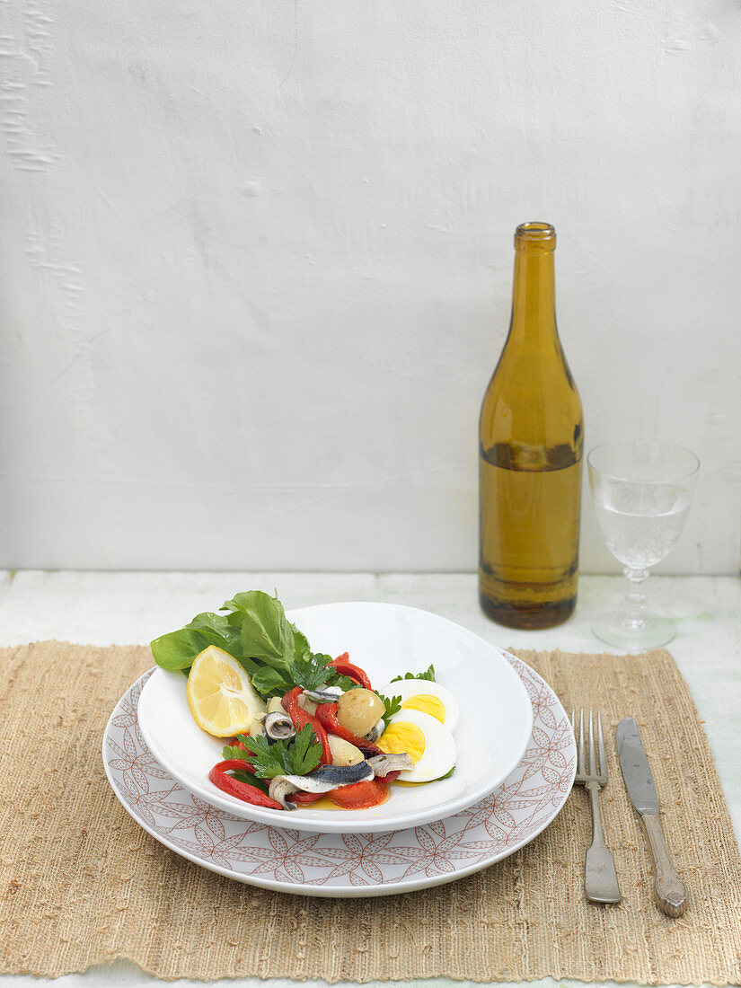 Salat aus Gemüse, gerösteter roter Paprika, hart gekochten Eiern, Kartoffeln und Sardinen