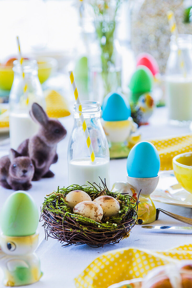 Gefärbte Ostereier auf bunt gedecktem Ostertisch