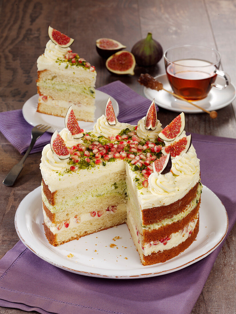 White chocolate cake with pistachios, pomegranate seeds and figs