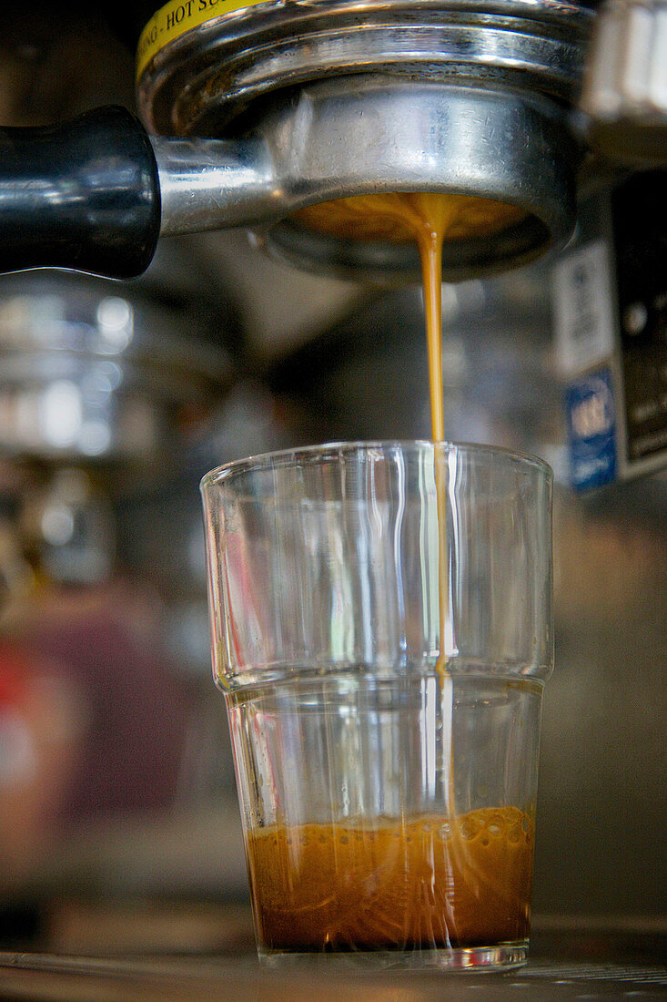 Espresso fließt vom Siebträger in ein Glas