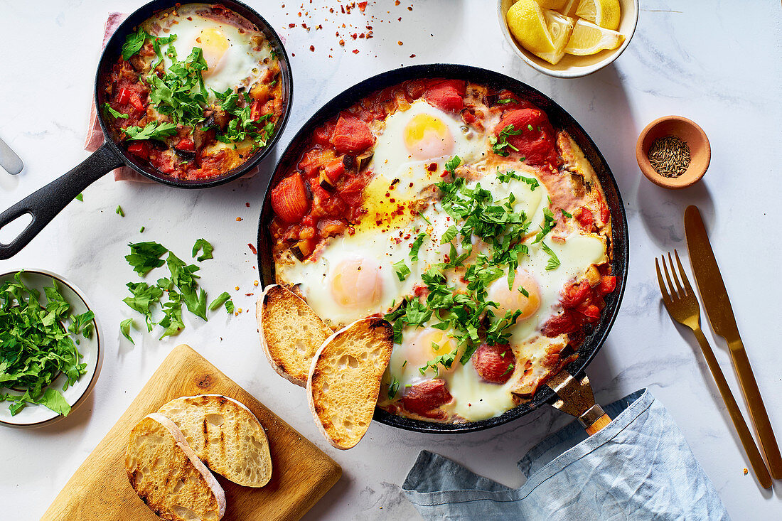 Shakshuka mit Gemüse, Kräutern, Tomatensauce und Röstbrot