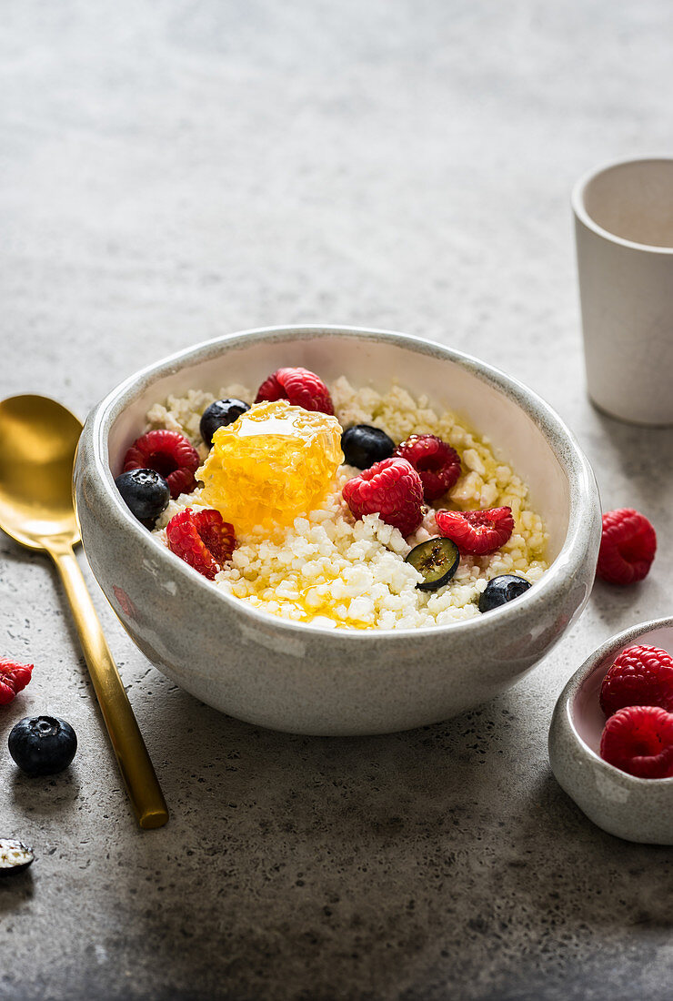 Körniger Frischkäse mit Honigwaben und frischen Beeren