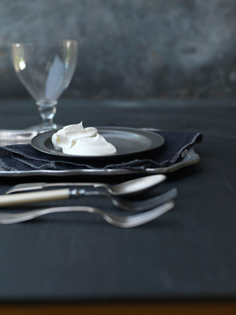 Whipped Cream Dollop on Pewter Plate With Cutlery, Napkin and Wine Glass