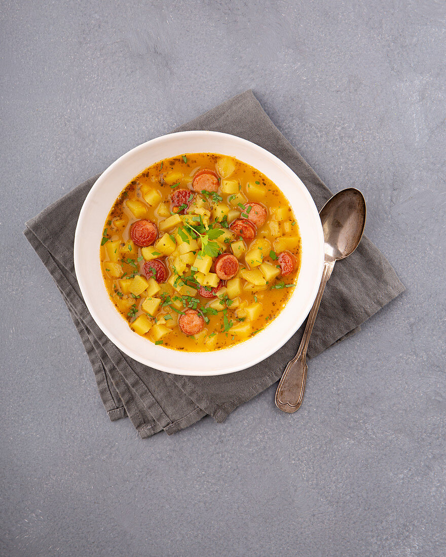 Savoury potato soup with grilled sausages