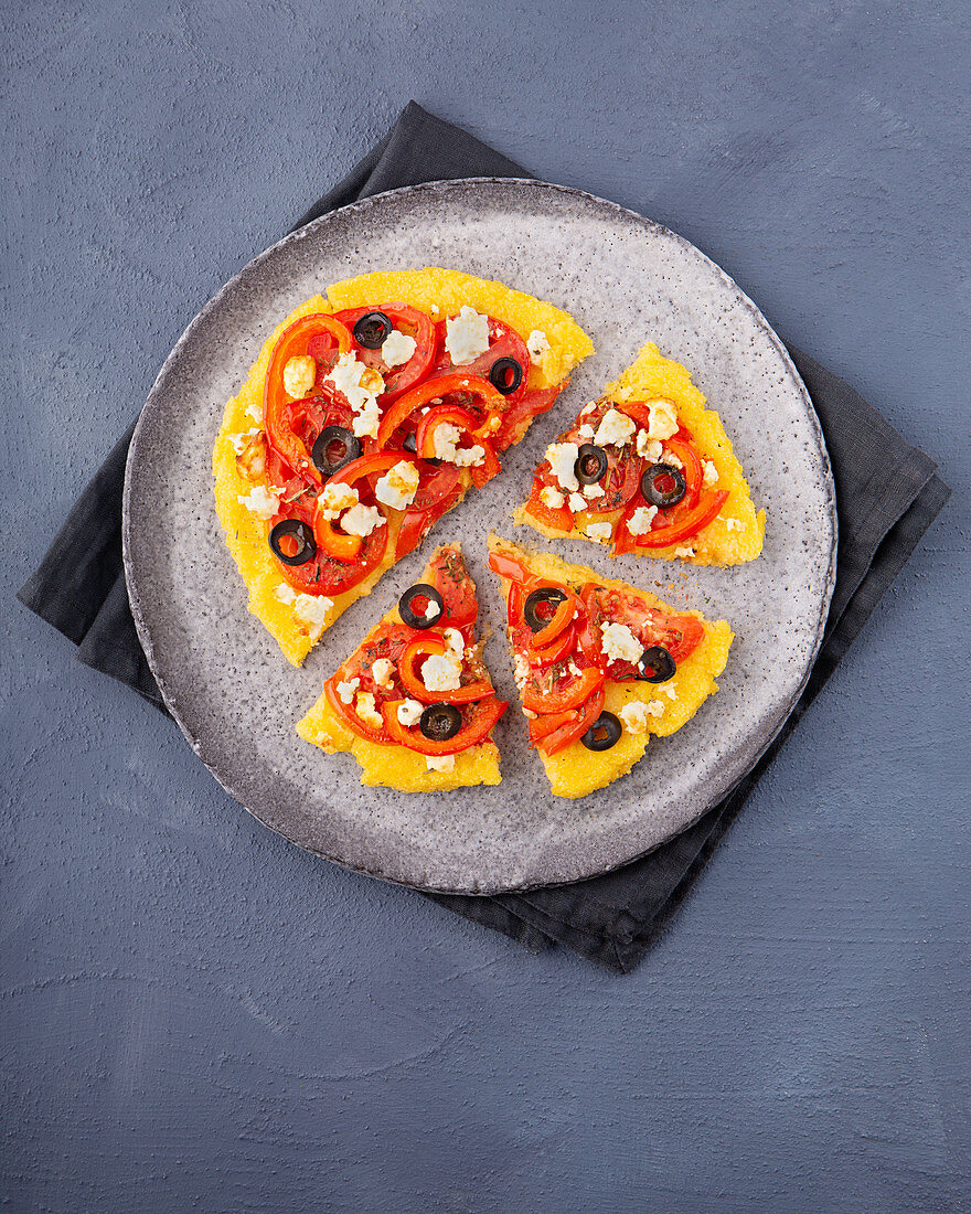 Polenta-Pizza mit Tomaten, Paprika, Oliven und Feta