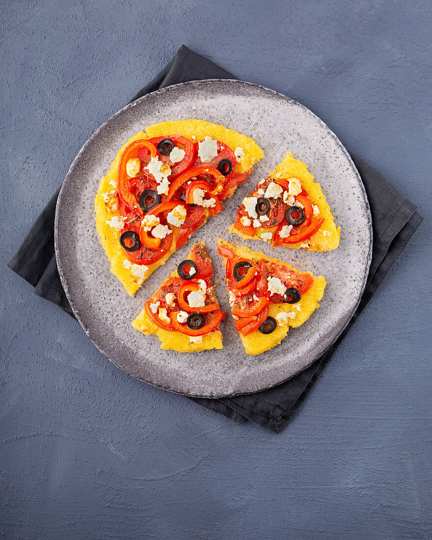 Polenta pizza with tomatoes, peppers, olives and feta cheese