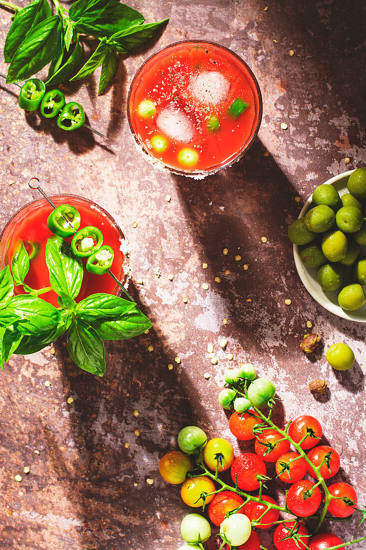 Glasses of Bloody Mary, with basil leaves and jalapenos
