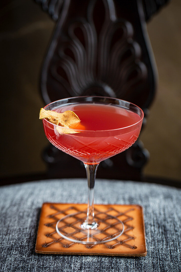 Red cocktail with dried apple slice