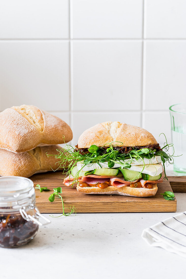 Ciabatta mit Schinken, Gurke, Brie, Erbsensprossen und Zwiebelmarmelade