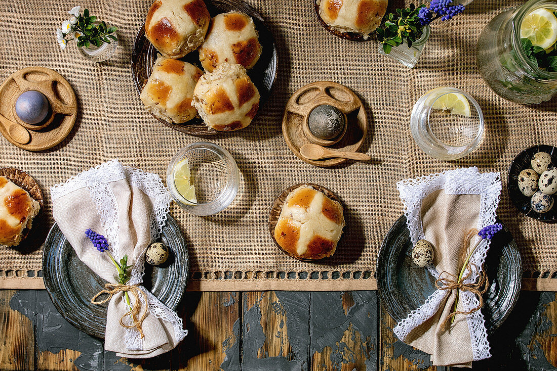 Easter table setting with eggs and hot cross buns