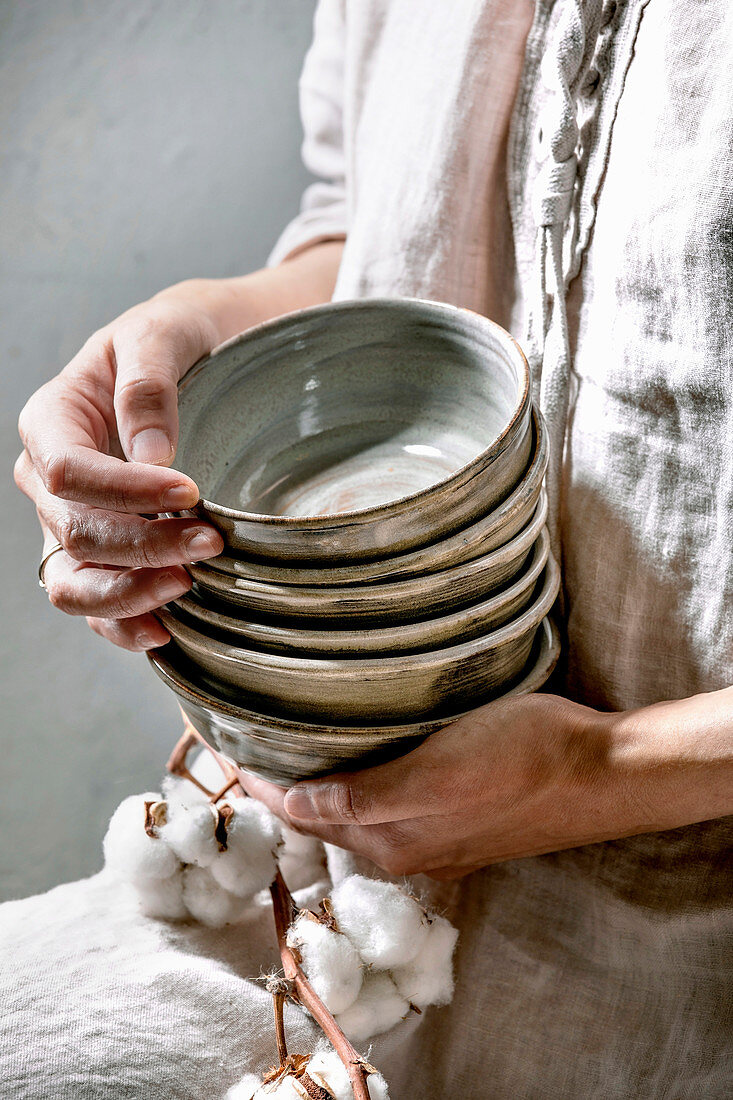 Woman holds set of empty craft ceramic bowls