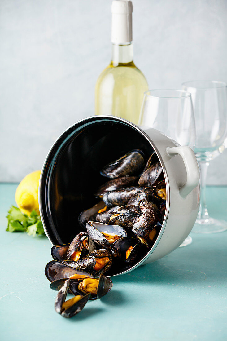 Pot of steamed mussels with lemon, herbs and white wine