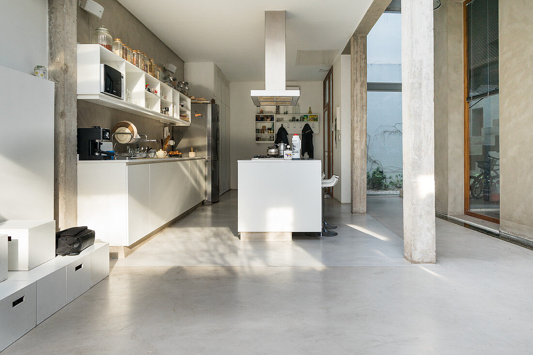 Island counter and concrete floor in open-plan kitchen