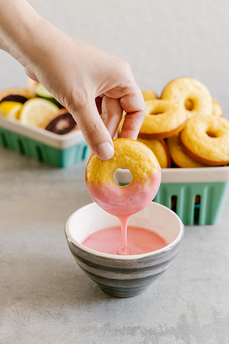 Mandel-Donuts in Blutorangenglasur tauchen