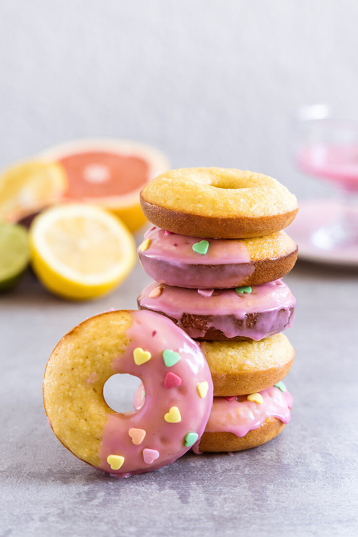 Blood orange glazed baked almond donuts decorated with heart shaped sprinkles