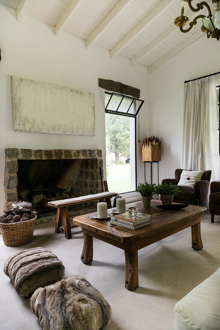 Wooden coffee table in front of rustic fireplace