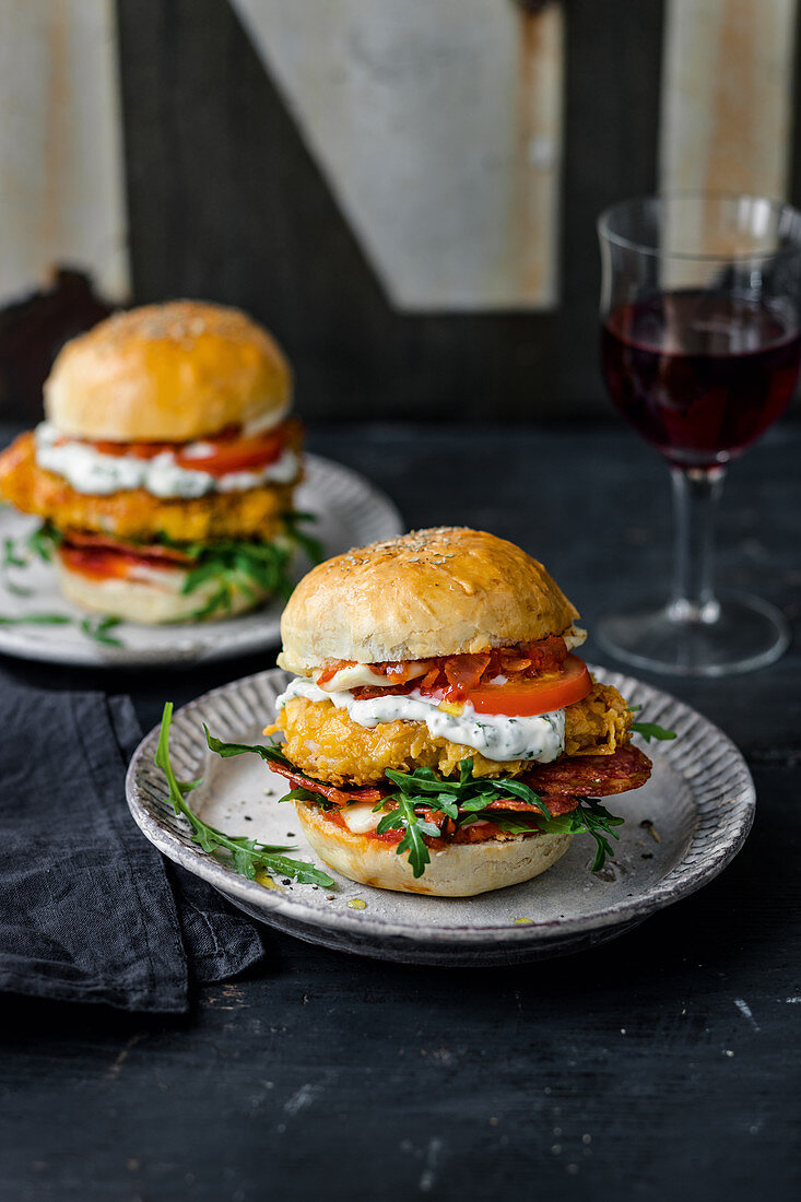 Pizza burger with crispy chicken, salami, arugula and tomatoes
