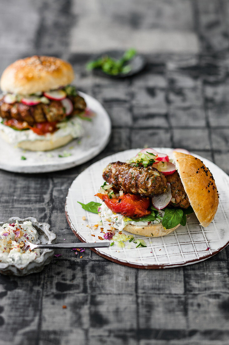 Lamb kebab burger with grilled tomatoes and an onion and herb mix