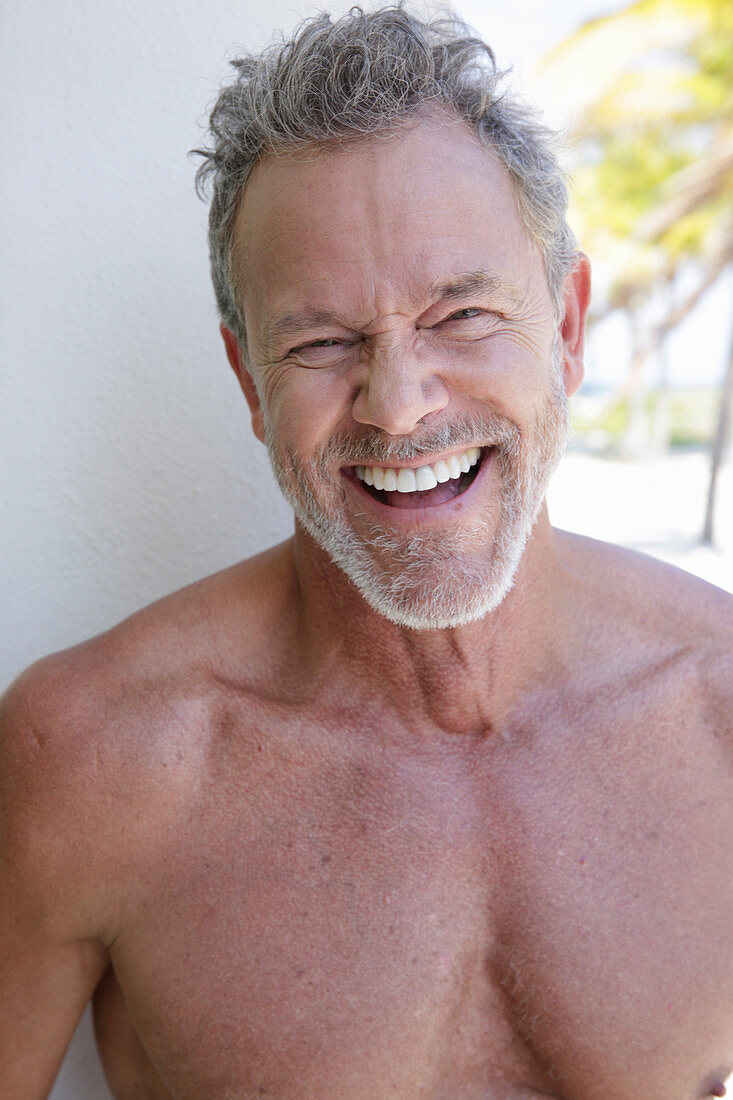 A laughing grey-haired man with a beard
