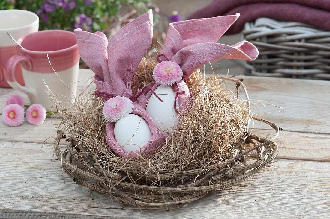 Unusual Easter nest made of clematis vines and hay, with Easter eggs tied in napkins, decorated with Tausendschon Roses