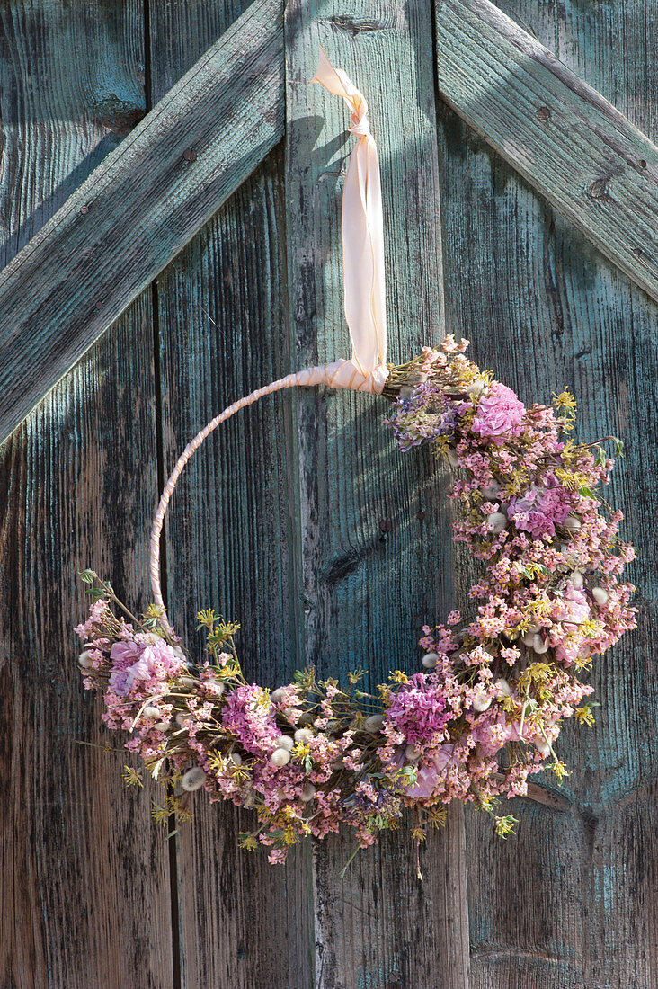 Door wreath with carnations, ranunculus flowers, beach lilac, cornelian cherry and catkin willow