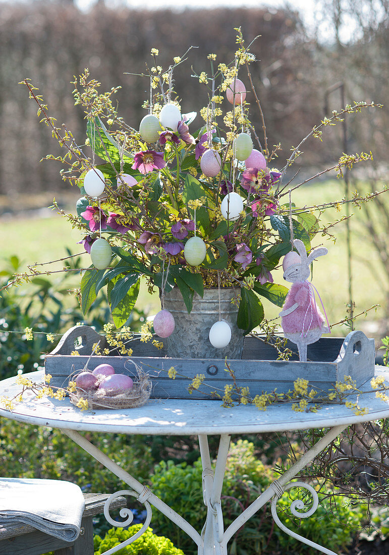 Easter bouquet of blossom branches and Lenten roses, Easter bunny, and Easter eggs