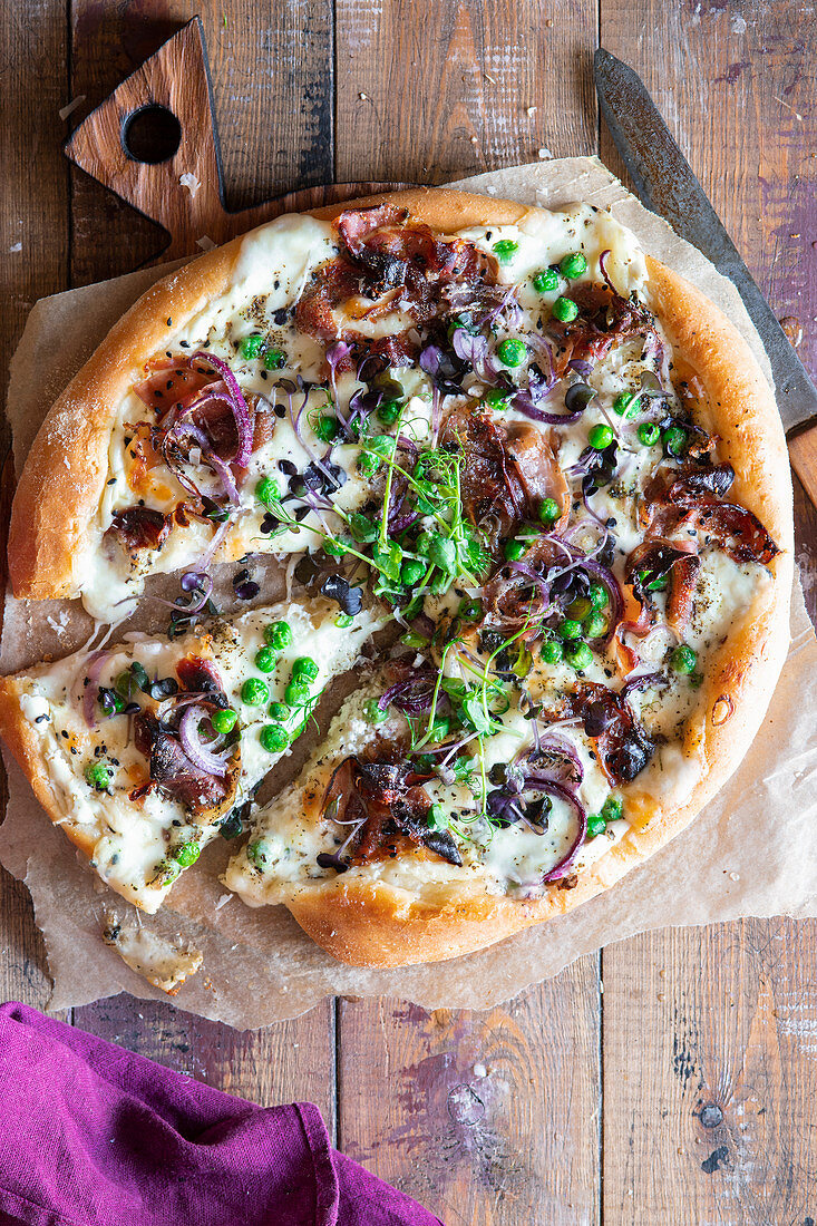 Pizza with proscuitto and green peas