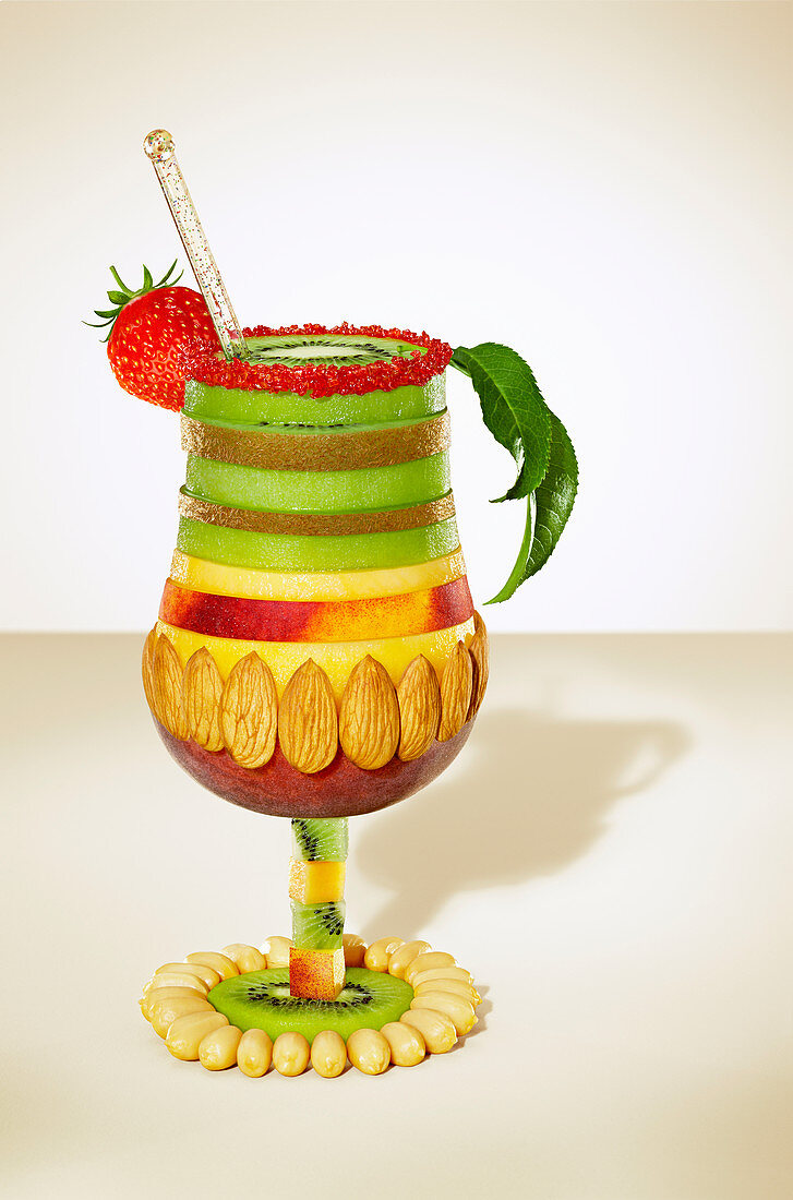Cocktail glass composition with sliced fruit and nuts