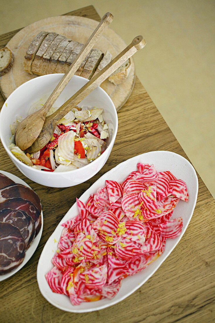 Colorful chioggia beetroot salads with ham plate and bread