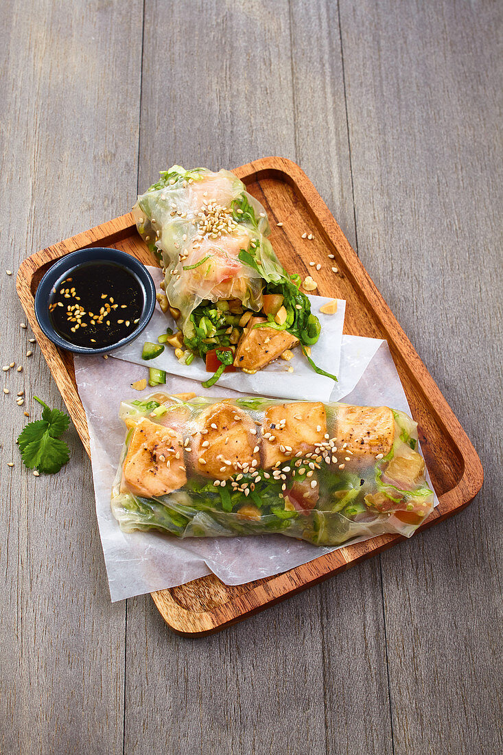 Asian summer rolls with salad, salmon filling and sesame