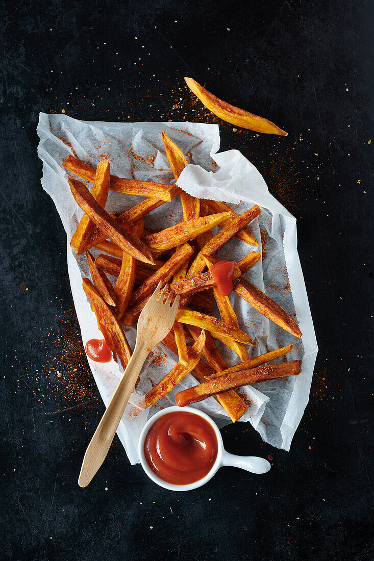 Seasoned sweet potato fries from the oven on baking paper