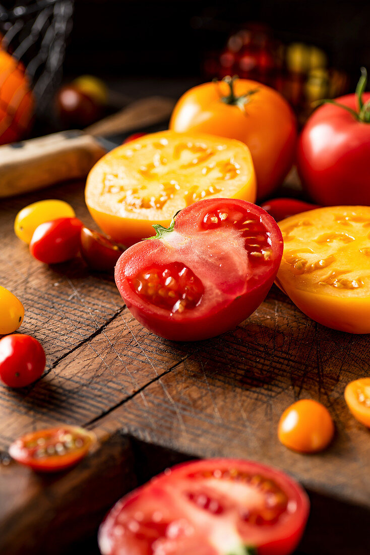 Halbierte gelbe und rote Tomaten auf Holzschneidebrett
