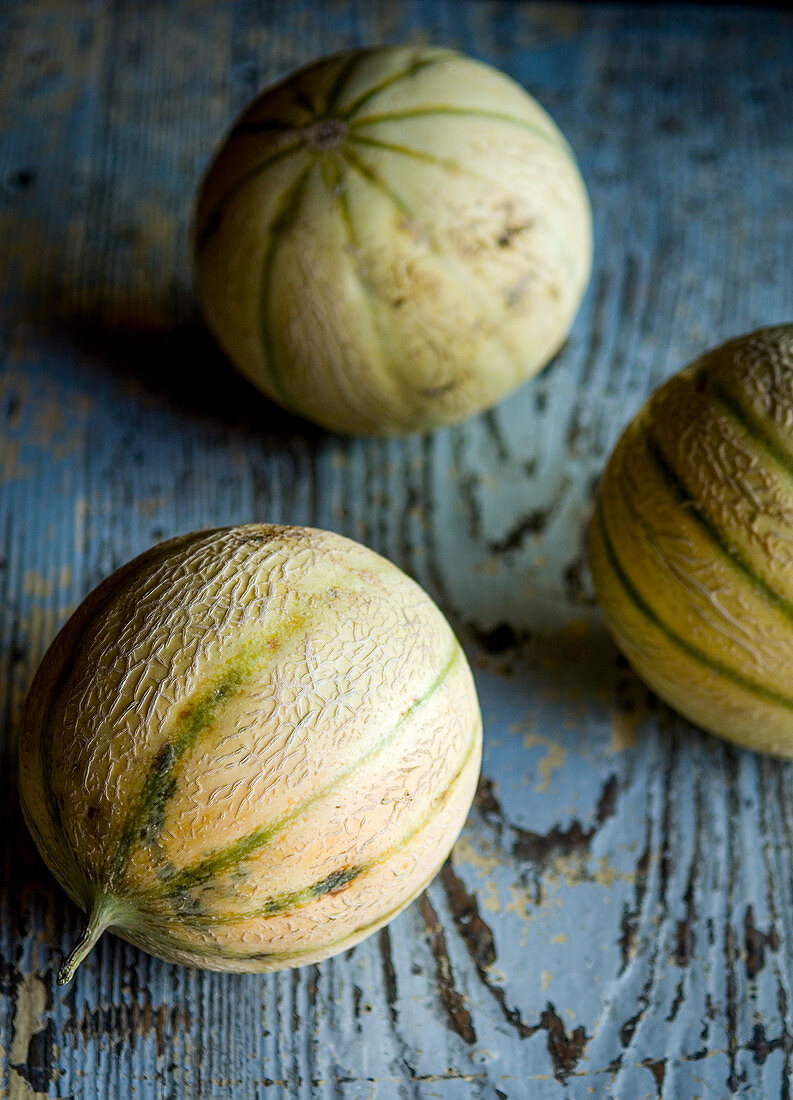 Charentais-Melonen auf blauem Holztisch