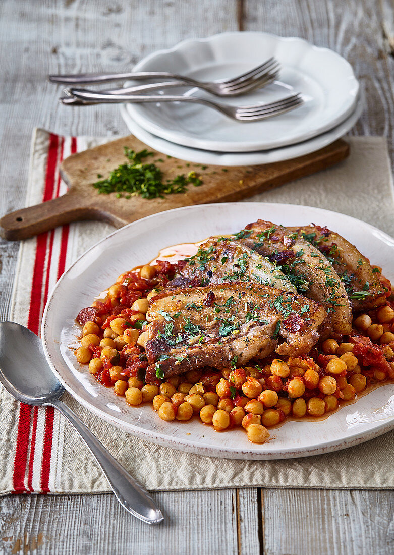 Geratener Schweinefleisch auf Kichererbsentopf mit Tomaten