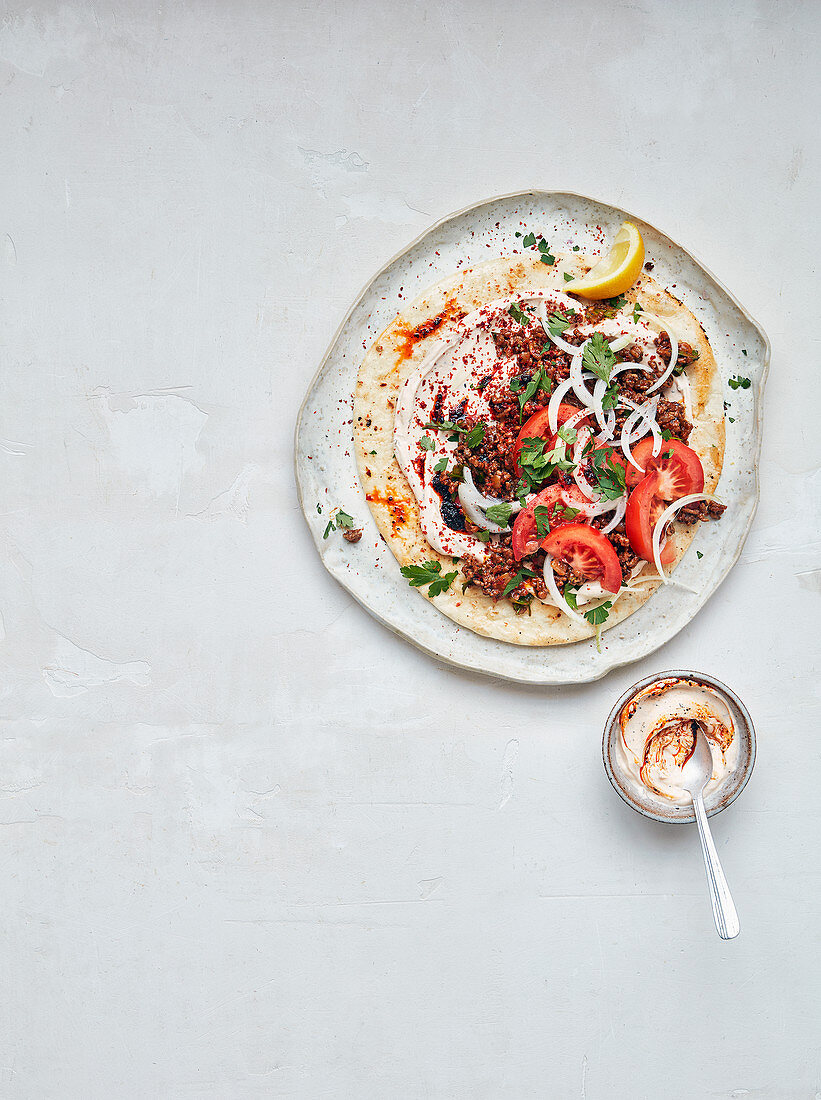 Urfa mit Hackfleisch, Tandoori-Joghurt, Tomaten und Zwiebeln