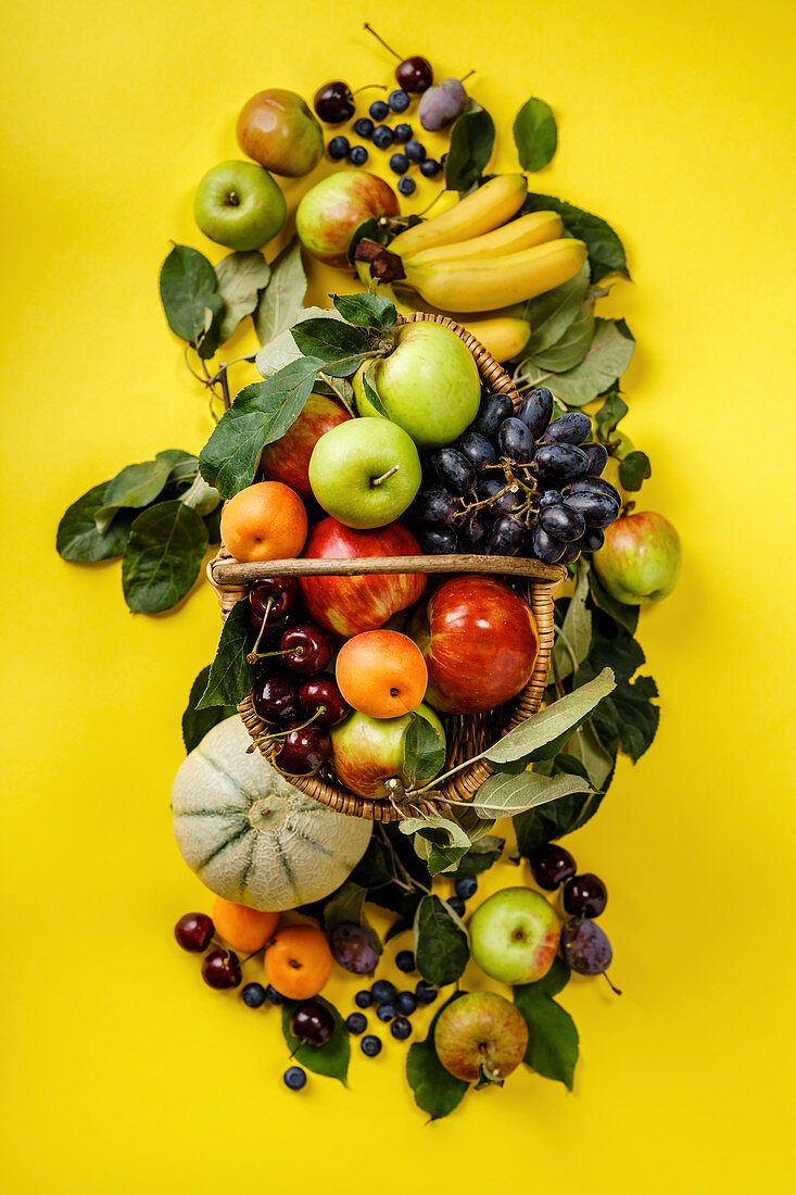 Frische Früchte und Beeren auf gelbem Untergrund