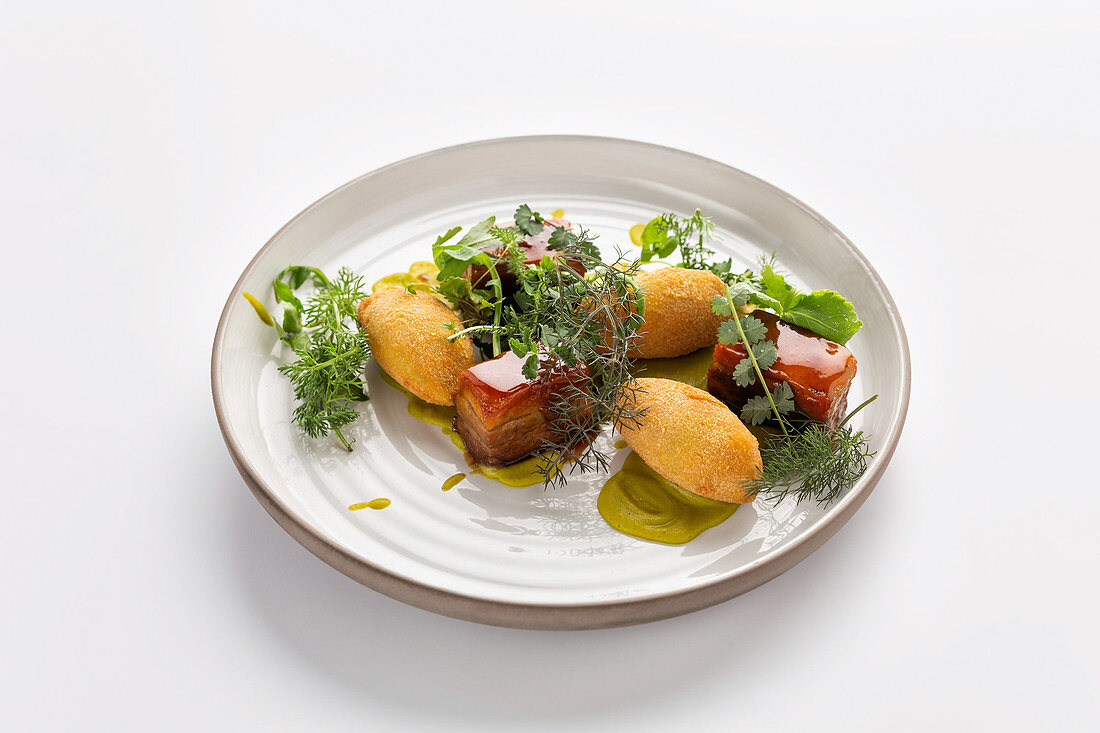 Glazed pork belly with croquettes and herb salad