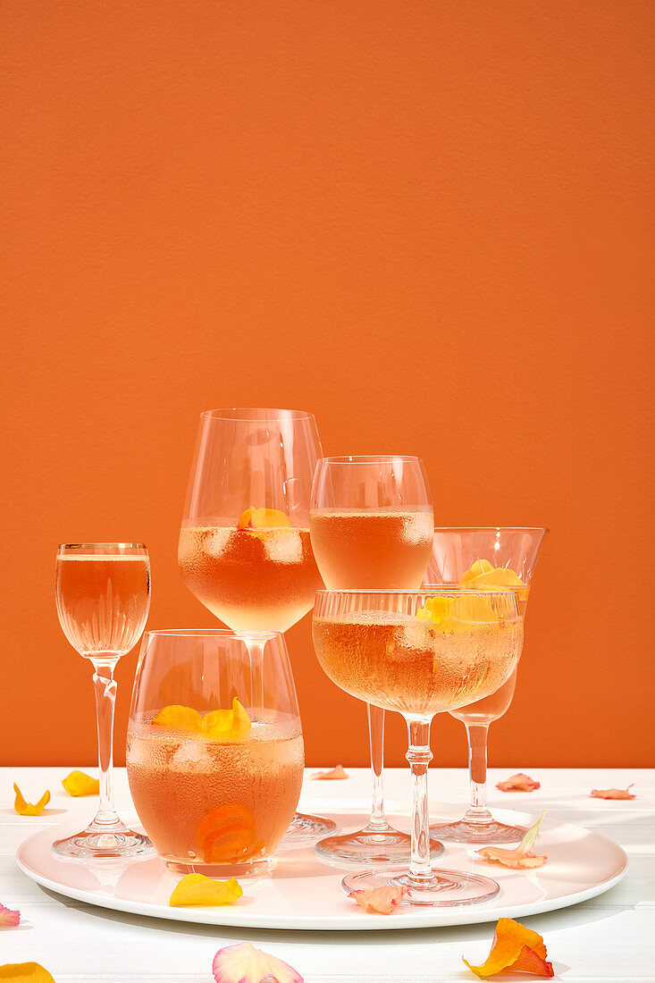 Champagne cocktails in various glasses and rose petals