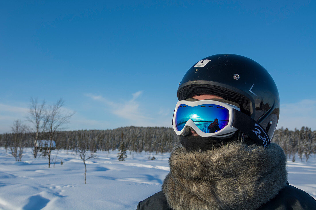 Tourist wearing a helmet for snowmobile driving, Sweden