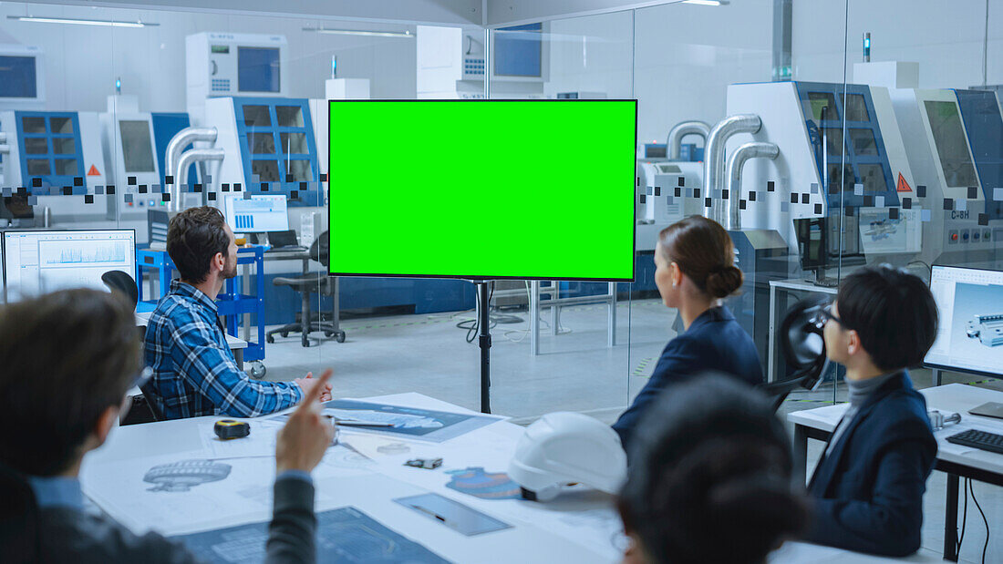 Team looking at a green screen in a meeting room
