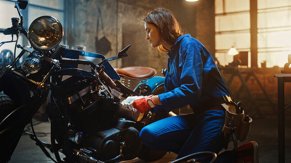 Mechanic working on a custom motorcycle in a garage