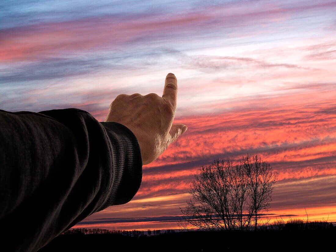 Hand pointing to the sunset