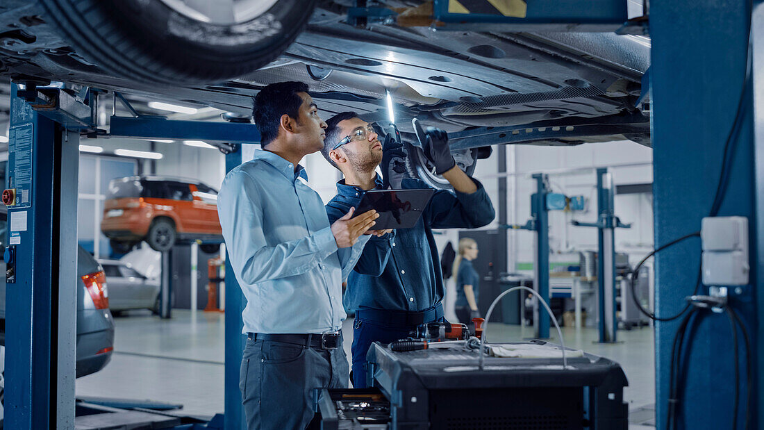 Mechanic and service manager inspecting a car