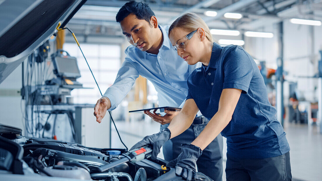 Mechanic and service manager inspecting a car