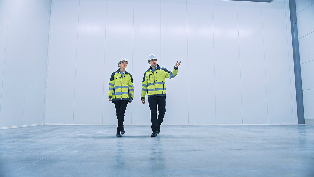 Engineers walking through an empty warehouse
