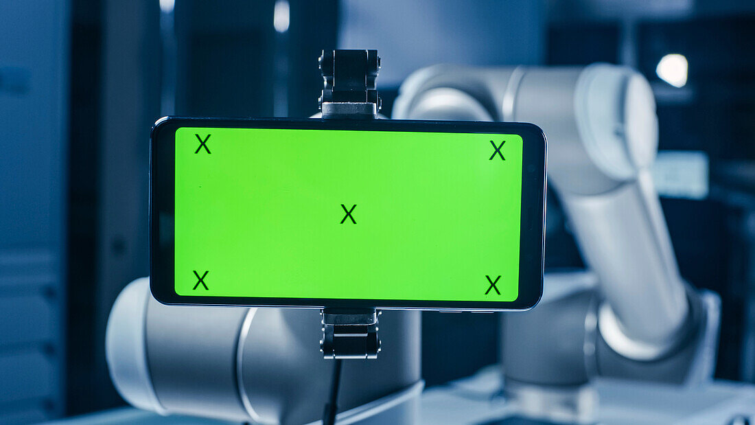 Robotic arm holding a green screen smartphone