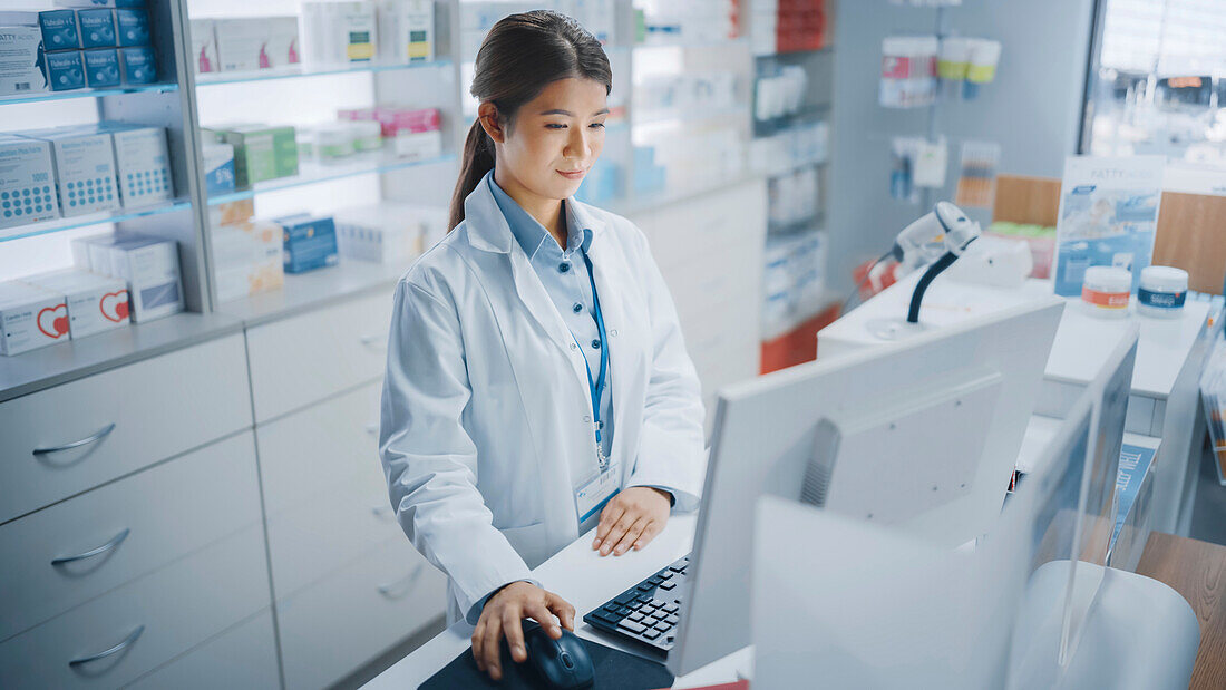 Pharmacist using a checkout computer