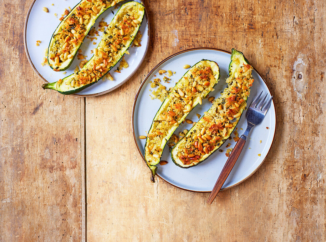 Stuffed baked courgettes with garlic and herb crumbs and pine nuts
