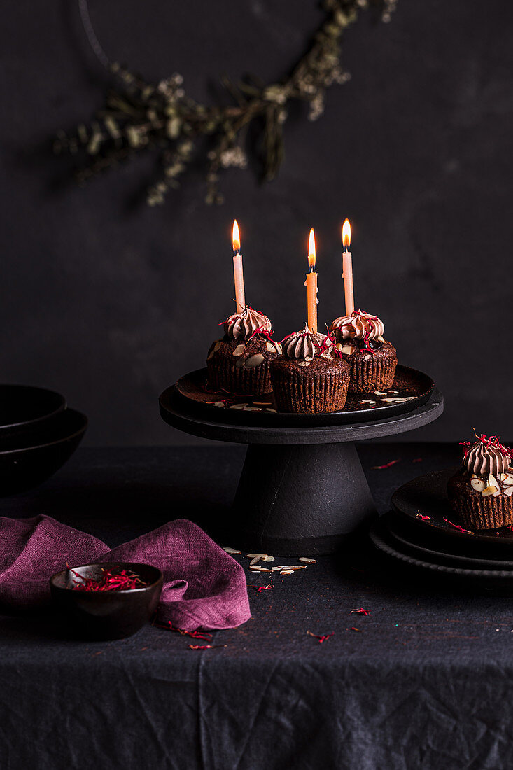 Schokocupcakes mit brennenden Kerzen