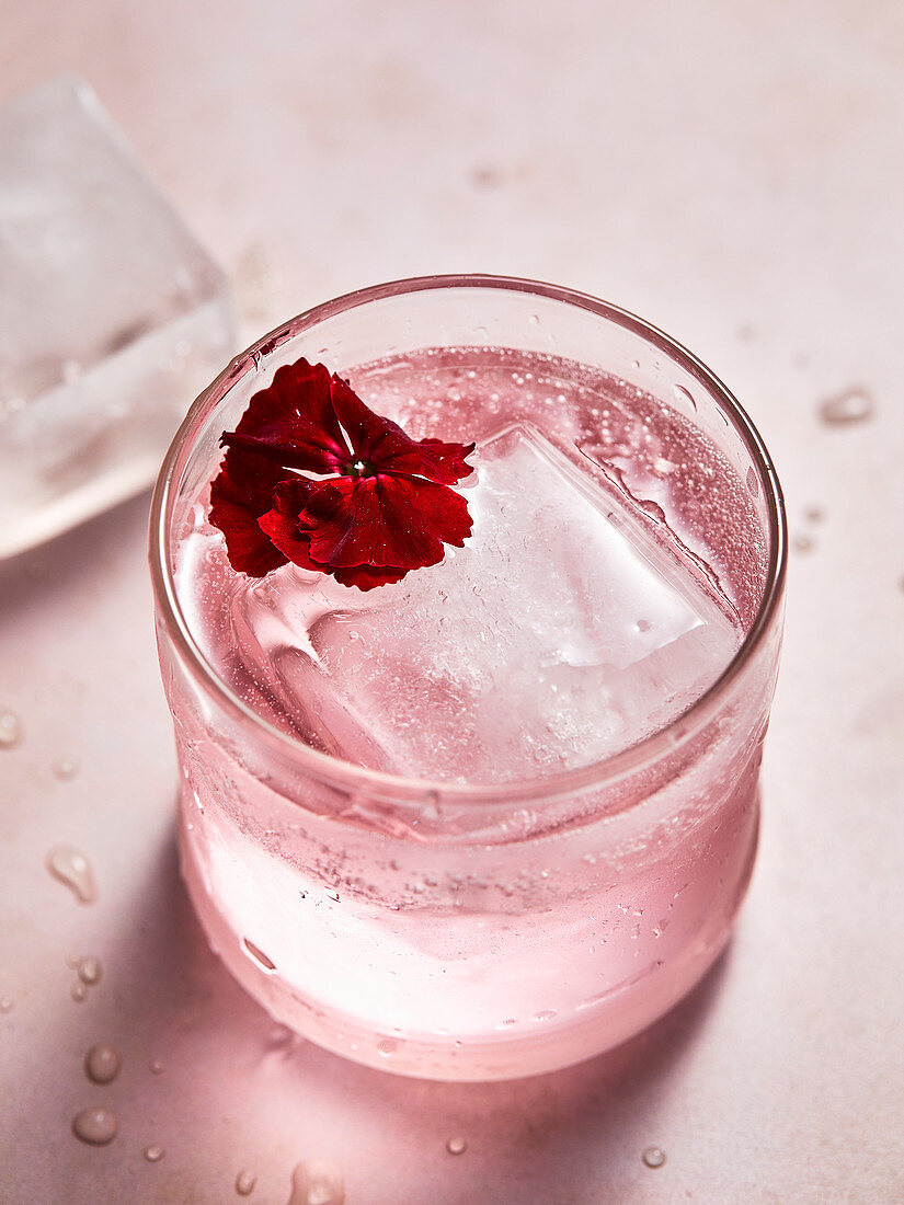 Pinkfarbener Rosendrink mit Eiswürfel